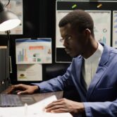 Detective inspector works in office, analyzing forensic evidence and conducts detailed background checks. Police officer identifying illegal activity, and gathering crucial information. Zoom-in shot.