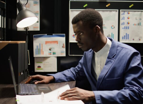 Crime scene analysis by male detective Detective inspector works in office, analyzing forensic evidence and conducts detailed background checks. Police officer identifying illegal activity, and gathering crucial information. Zoom-in shot.